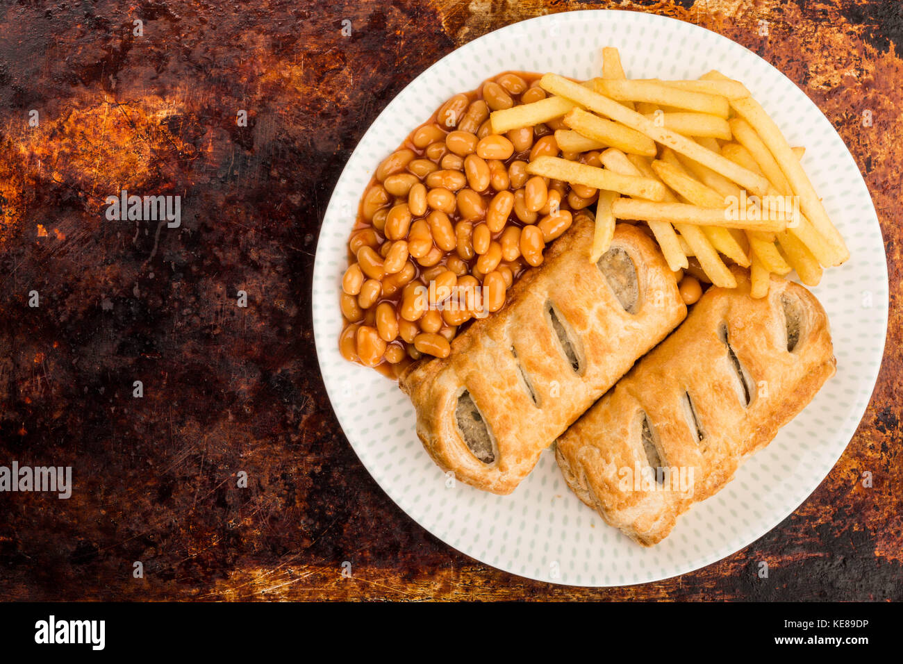 Sausage Rolls With Baked Beans Chips And French Fries On A Distressed