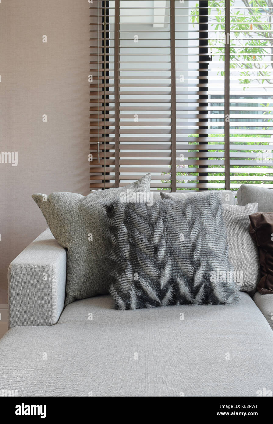 Fluffy pillows and earth tone pillows setting on beige L shape sofa