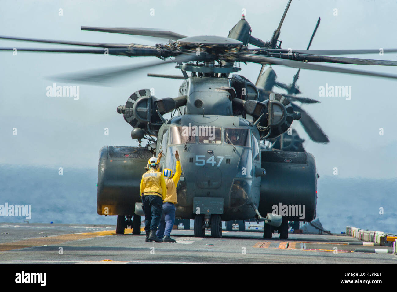 Sailors signal the takeoff of an MH-53E Sea Dragon helicopter Stock Photo