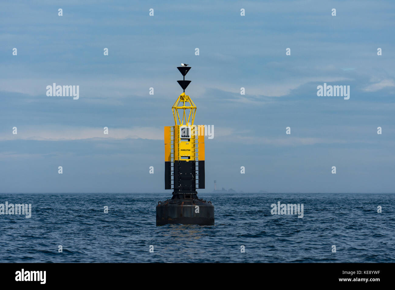The Runnel Stone South Cardinal marker buoy with Longships lighthouse