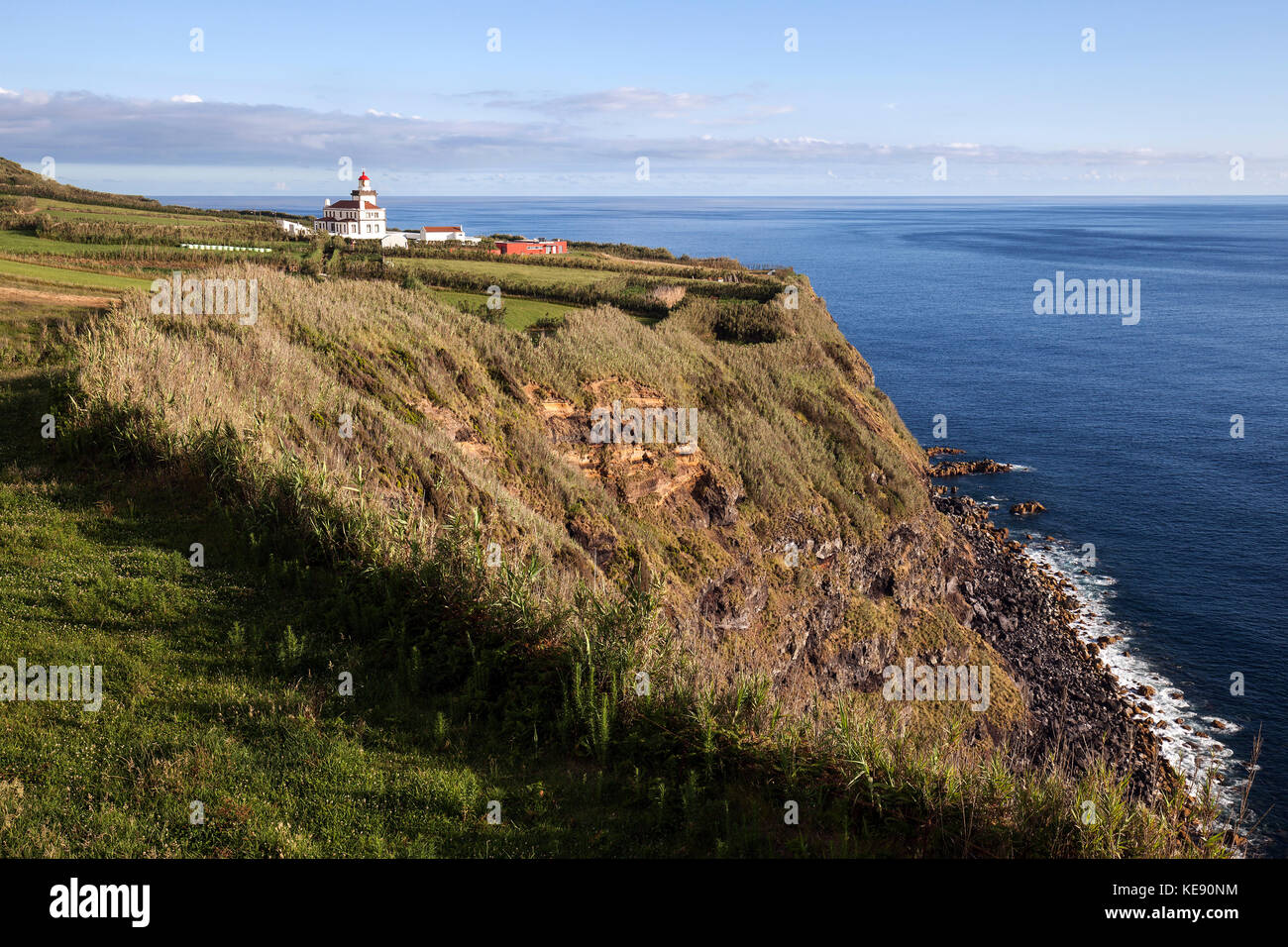 Steep coast with the lighthouse of Ginetes, Sao Miguel Island, Azores, Portugal Stock Photo