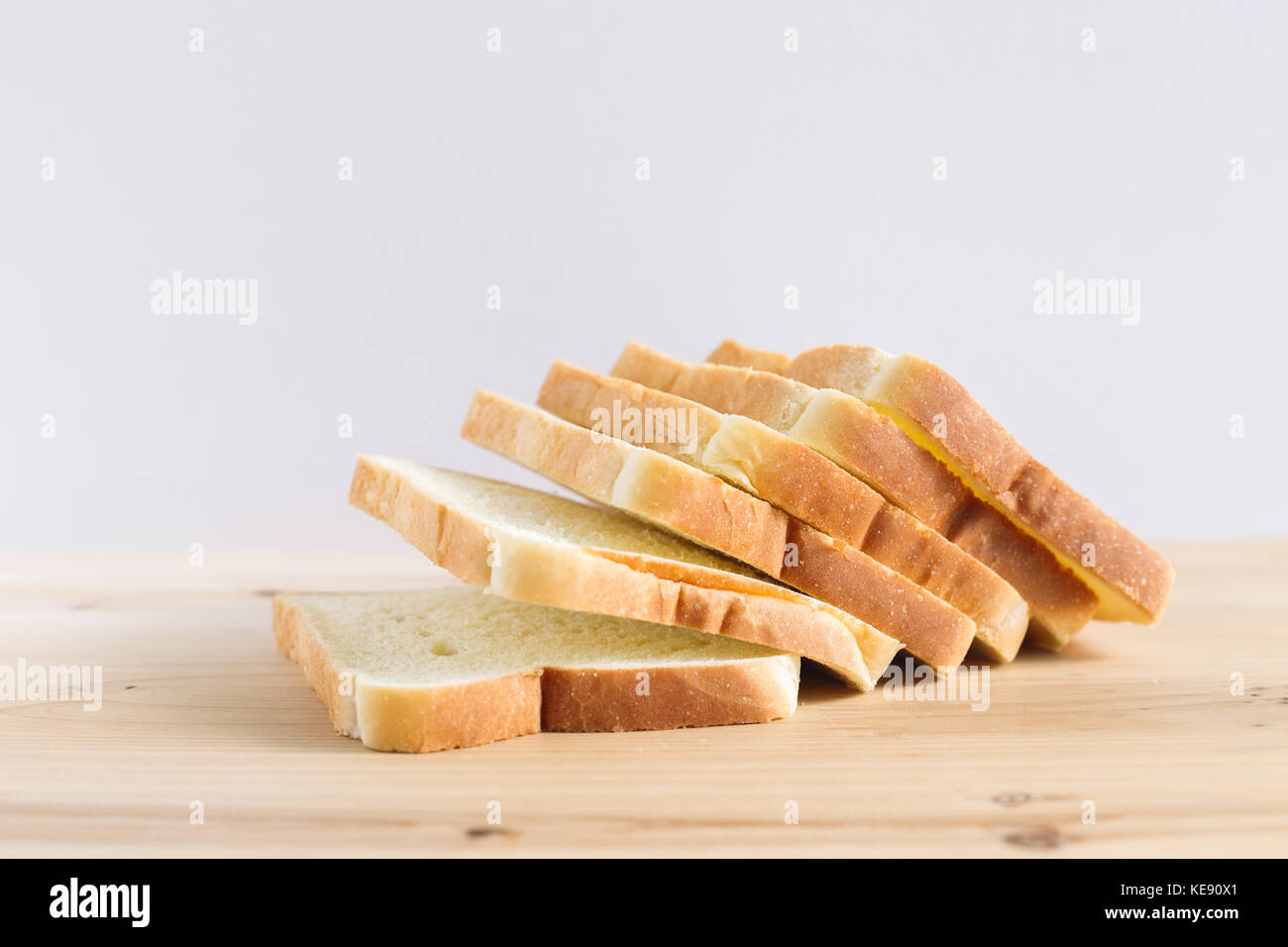 Sliced plain bread on wooden table Stock Photo