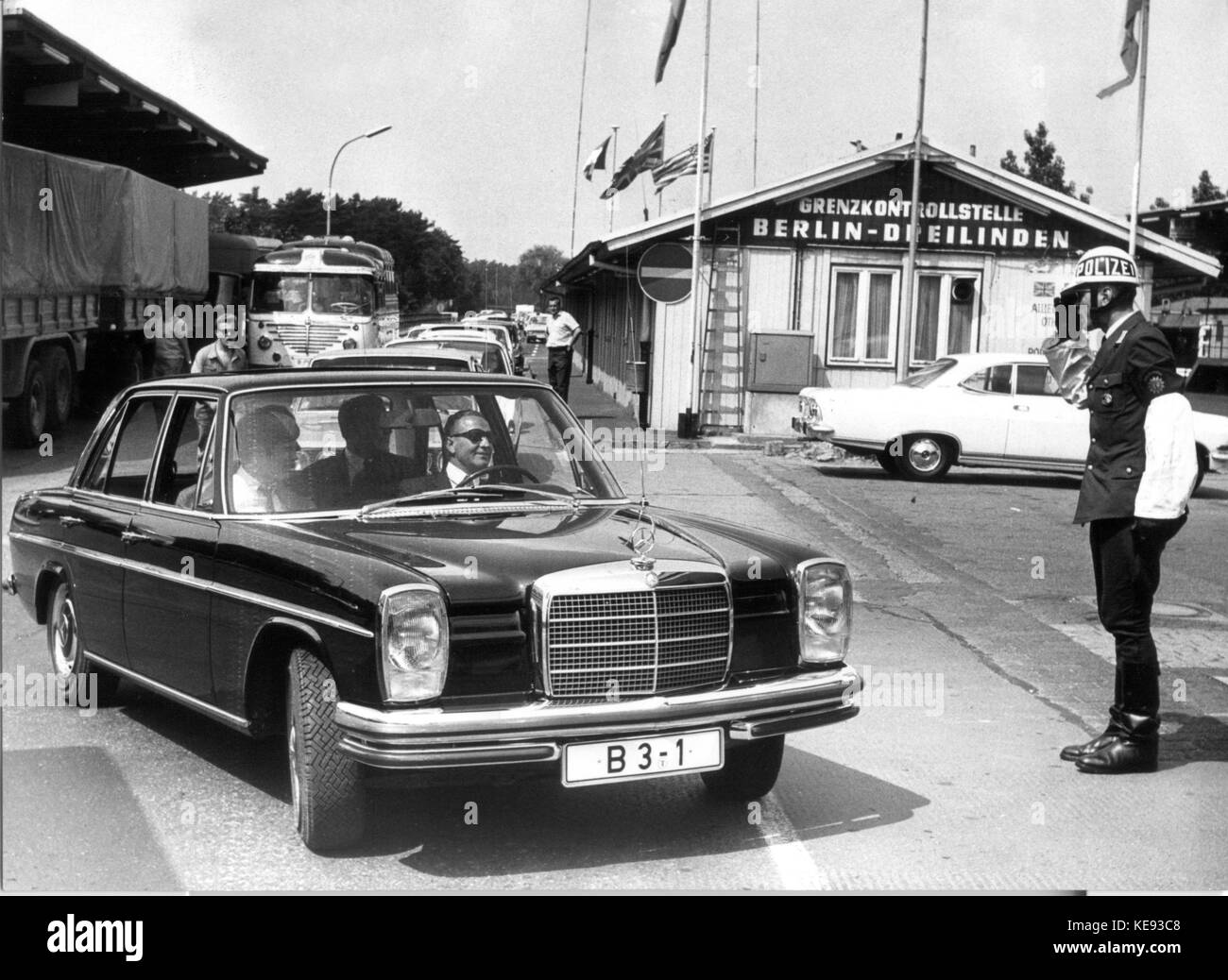 The limousine with Berlin's Lord Mayor Klaus Schuetz his wife Heide and his personal consultant Guenter Struve passes a saluting policeman at the check point 'Dreilinden' before entering the GDR in Berlin, Germany, 14 June 1969. Klaus Schuetz (of Germany's Social Democratic Party SPD) was a close associate of late German Chancellor Willy Brandt. He succeeded Mr Albertz as Berlin's Lord Mayor in 1967 and led the city government until his resignation on May 2nd 1977. The same year he was appointed German ambassador in Israel, an office he held until 1981. From 1981 to 1987 he served as director  Stock Photo