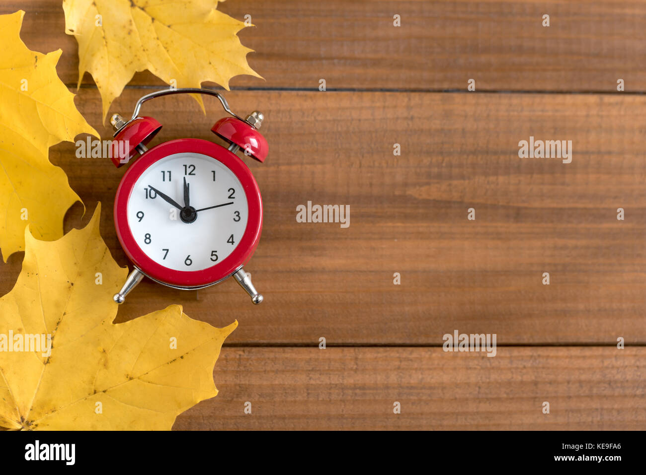 Top view of red vintage alarm clock on wooden background. Time change concept. Stock Photo