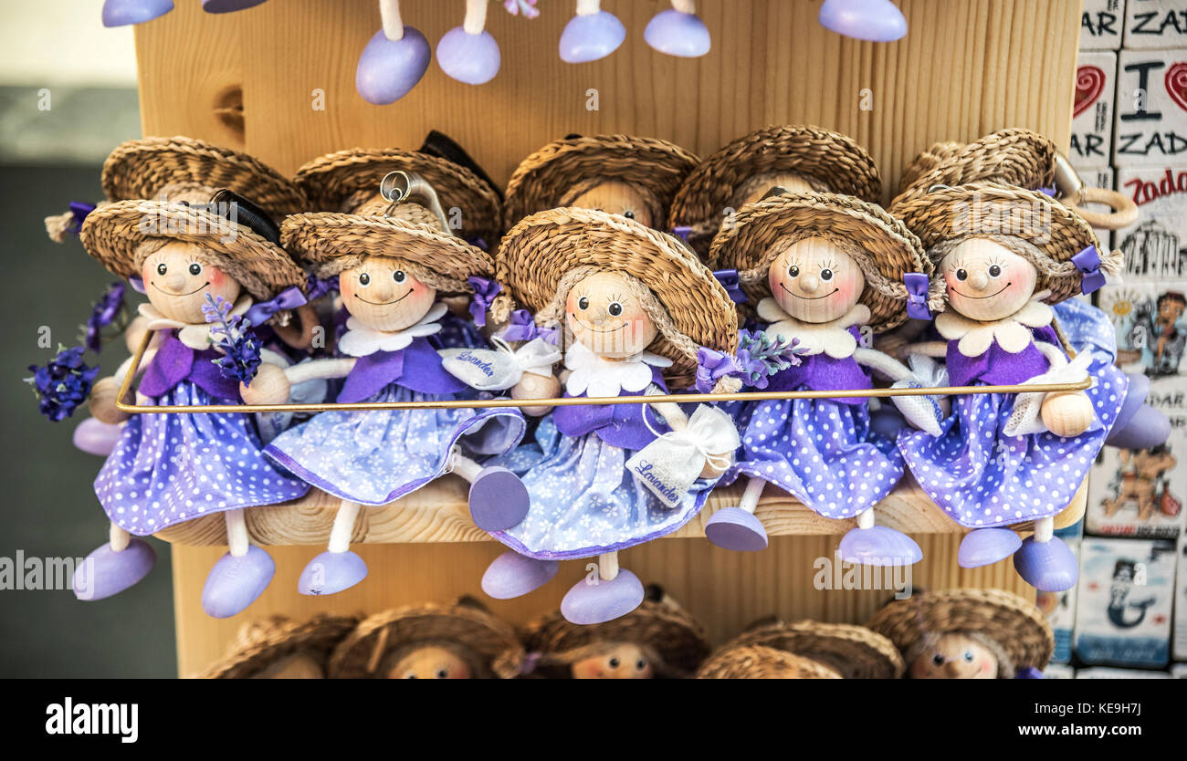 Wooden dolls dressed in purple outfits. Stock Photo