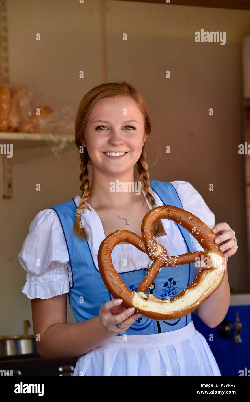 Beautiful young woman with braided hair wearing traditional Swiss dirdl  dress holding fresh large pretzel at Oktoberfest in New Glarus, Wisconsin,  USA Stock Photo - Alamy