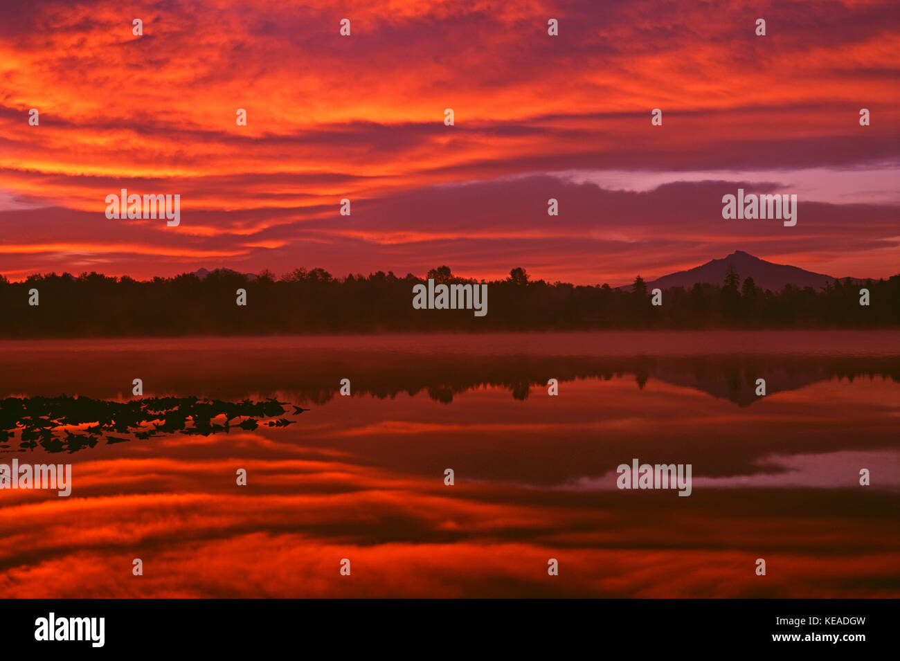 Dramatic sunrise over Lake Cassidy with Mount Pilchuck reflecting in