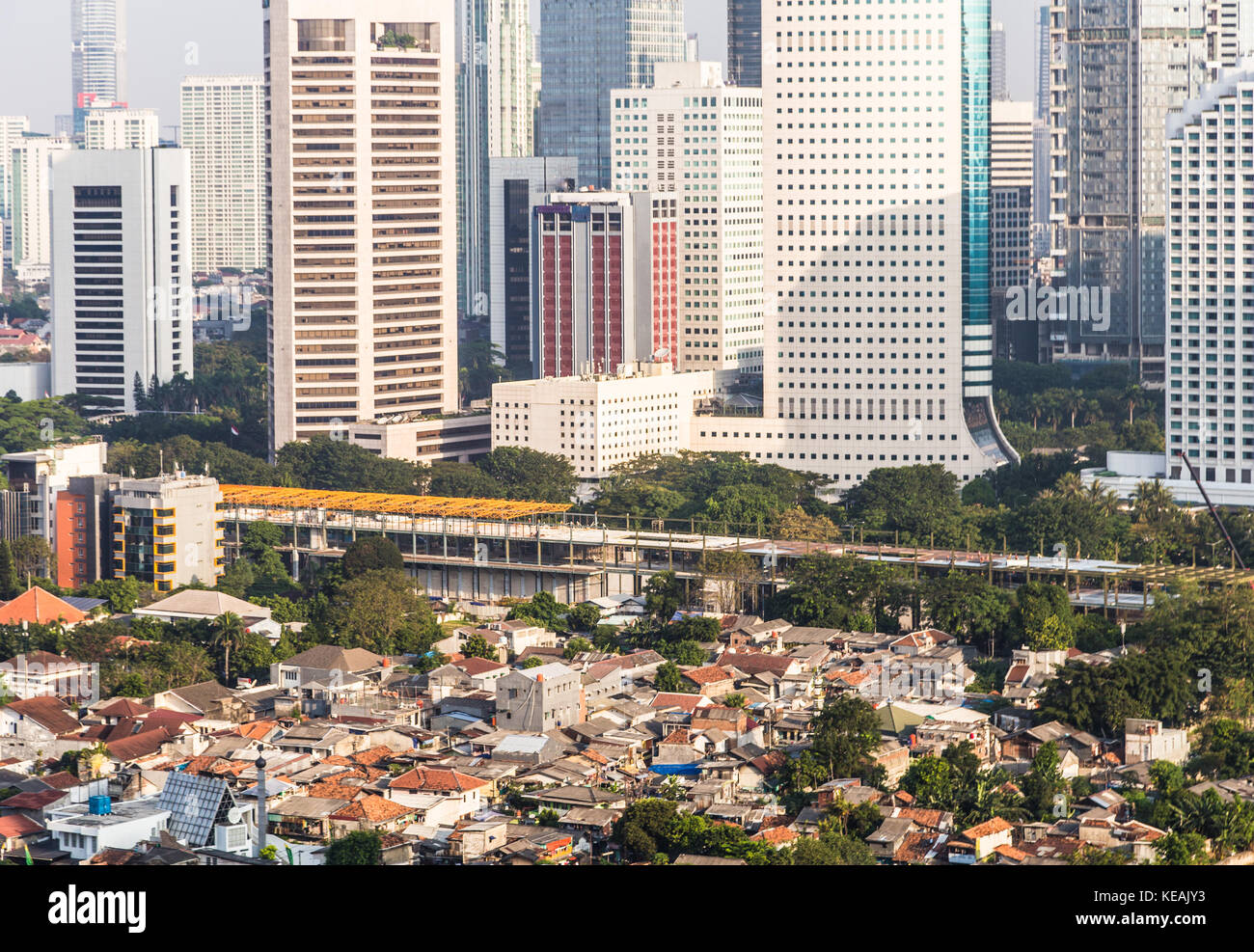 Middle to low class residential district contrasts with the modern skyscrapers of the business district of Jakarta in Indonesia capital city. Stock Photo