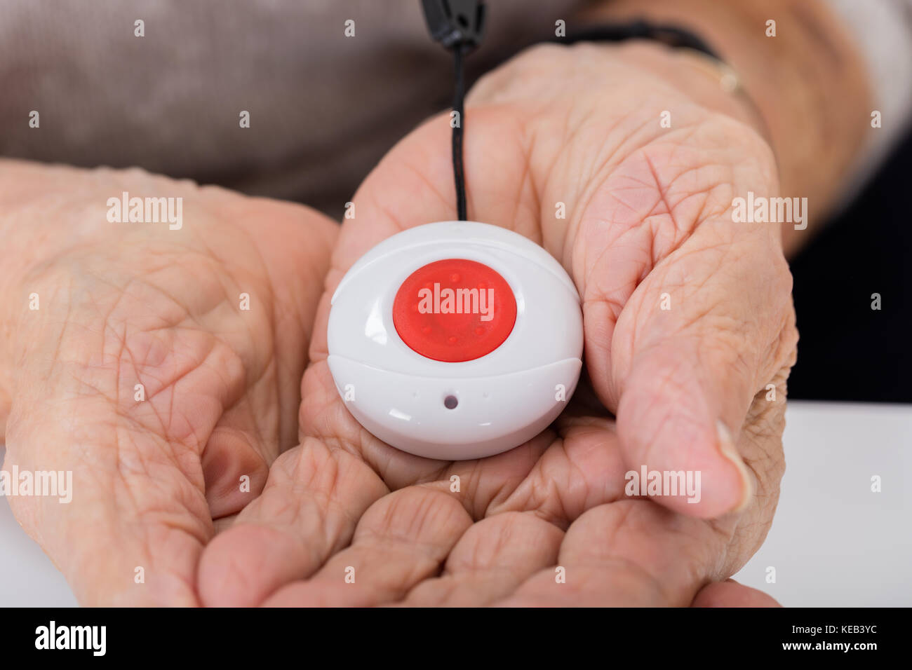 Closeup Of Senior Woman Holding Alarm Button For Emergency Stock Photo