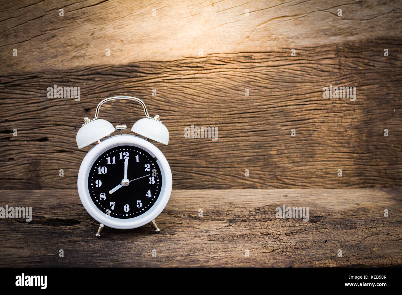 White classic alarm clock on wood background Stock Photo Alamy
