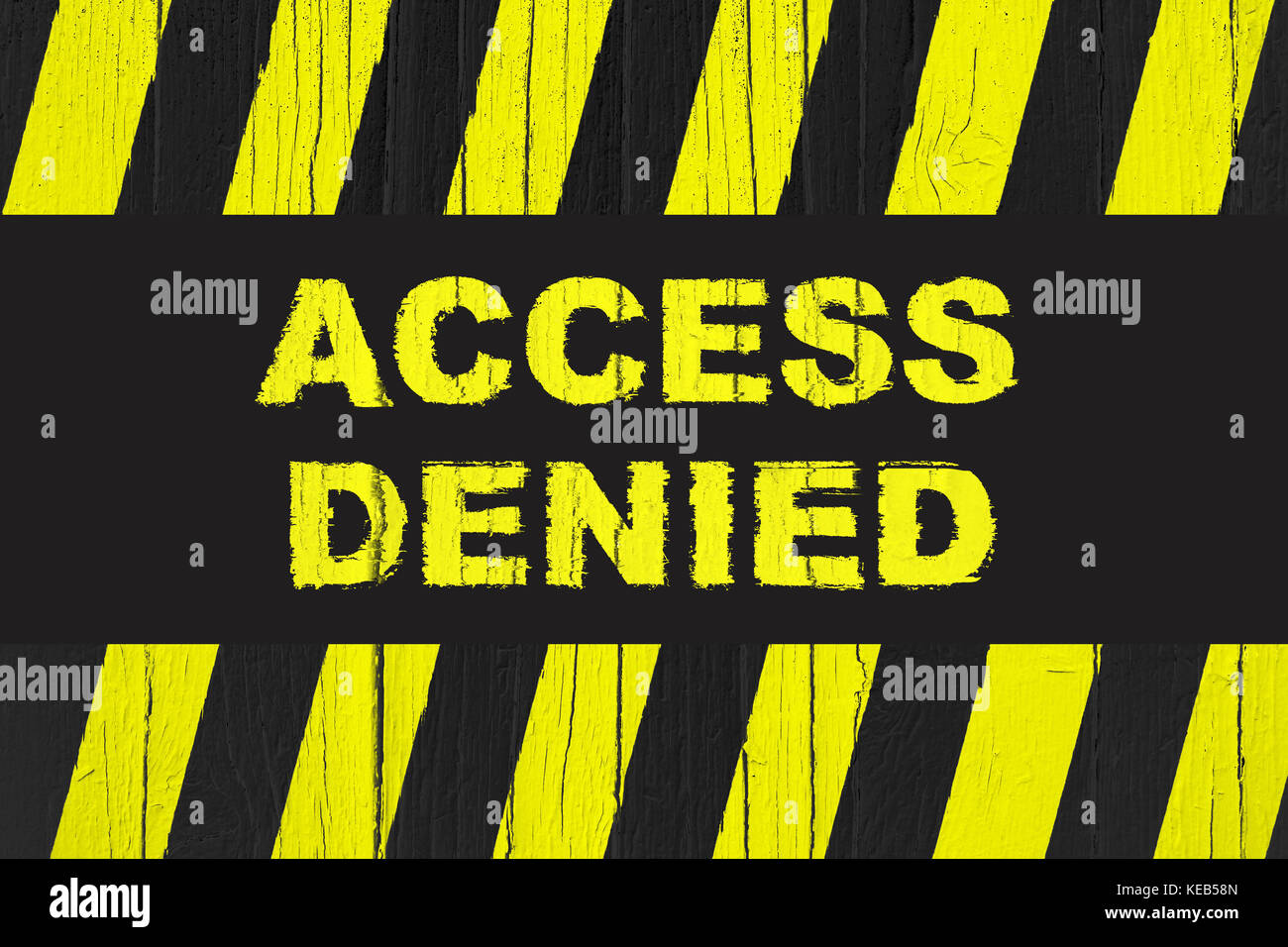 Access denied warning sign with yellow and black stripes painted over cracked wood. Sign usually used with meaning: do not enter the area, caution, da Stock Photo