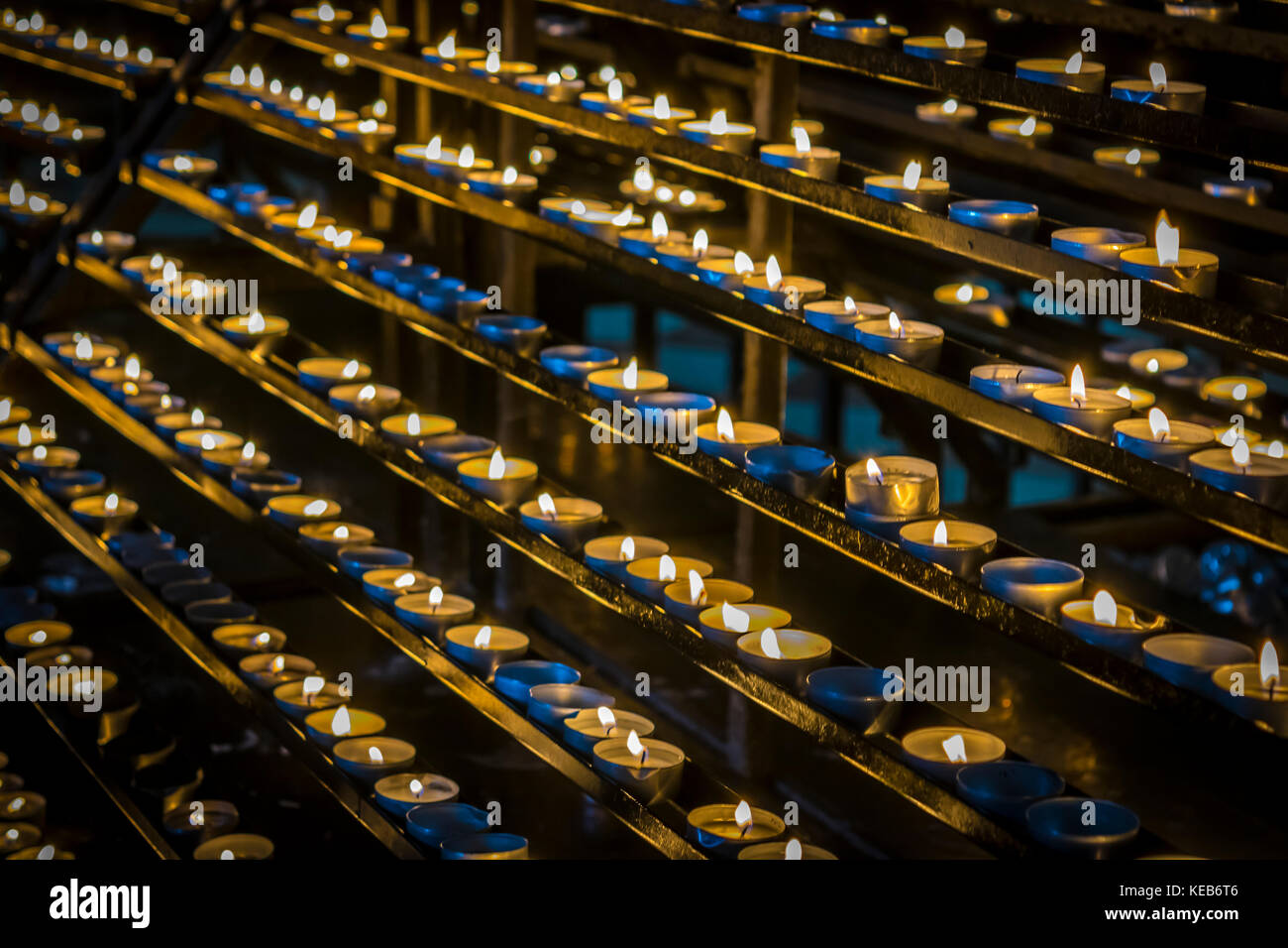 Candles glow in dark. Christian religion, prayer concept. Burning candles, candlelight in catholic church. Stock Photo