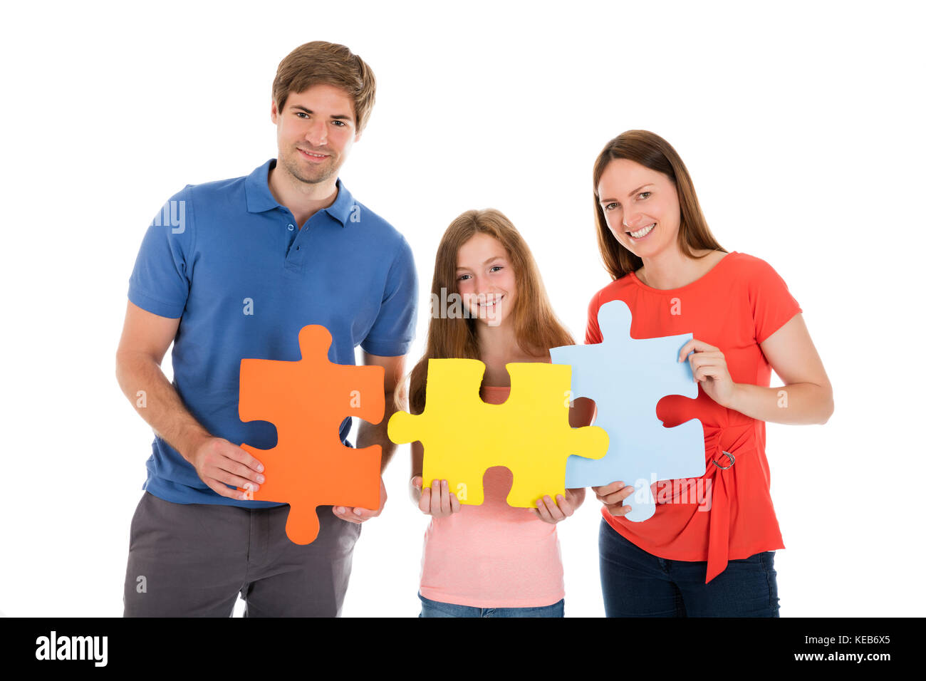 Portrait Of A Happy Family Holding Jigsaw Puzzle Pieces Stock Photo - Alamy