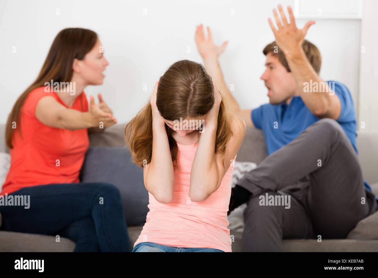 Upset Girl Covering Her Ears In Front Of Parent Having Argument Stock