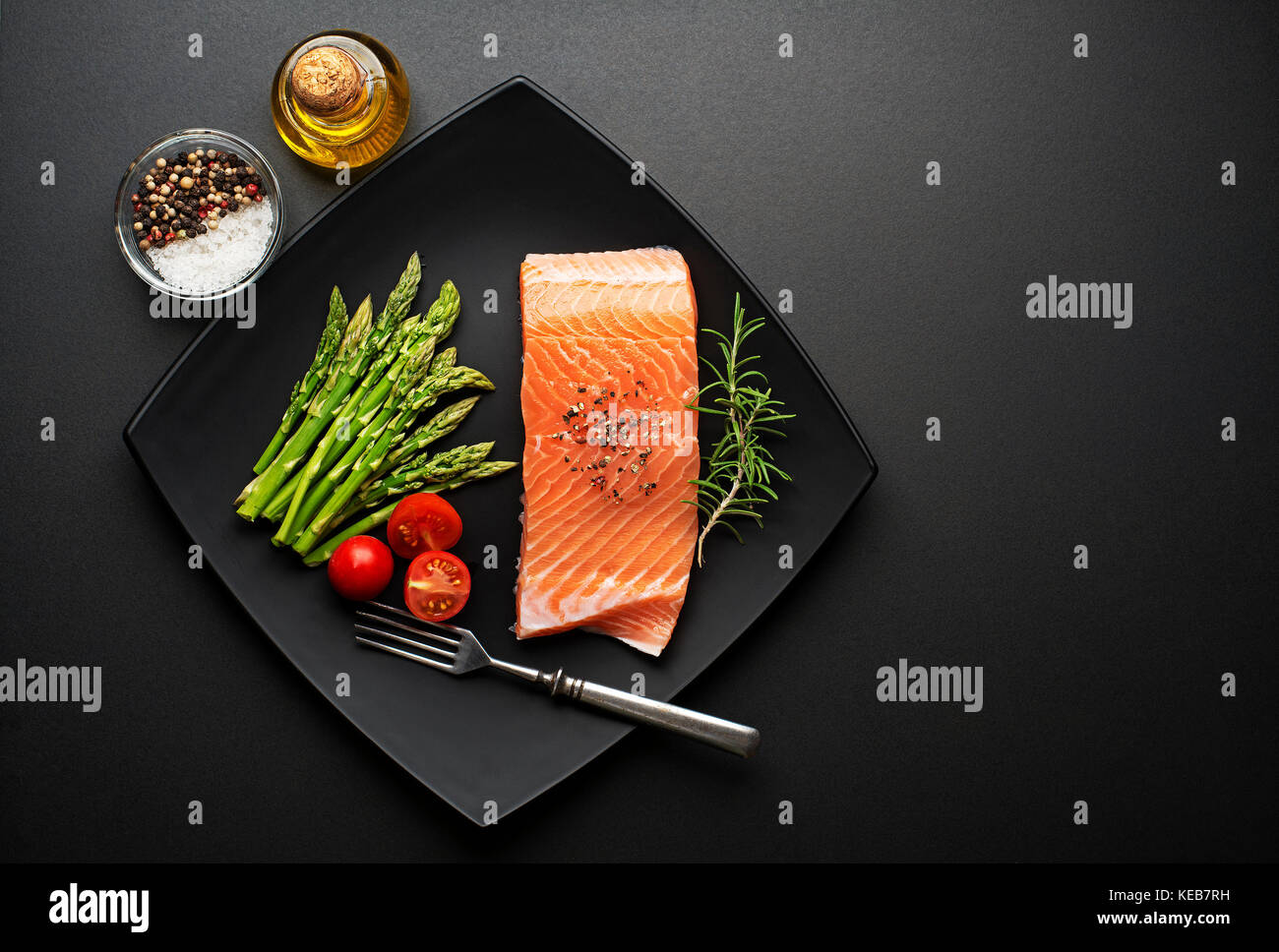 Raw steak of salmon with fresh ingredients on black background Stock ...