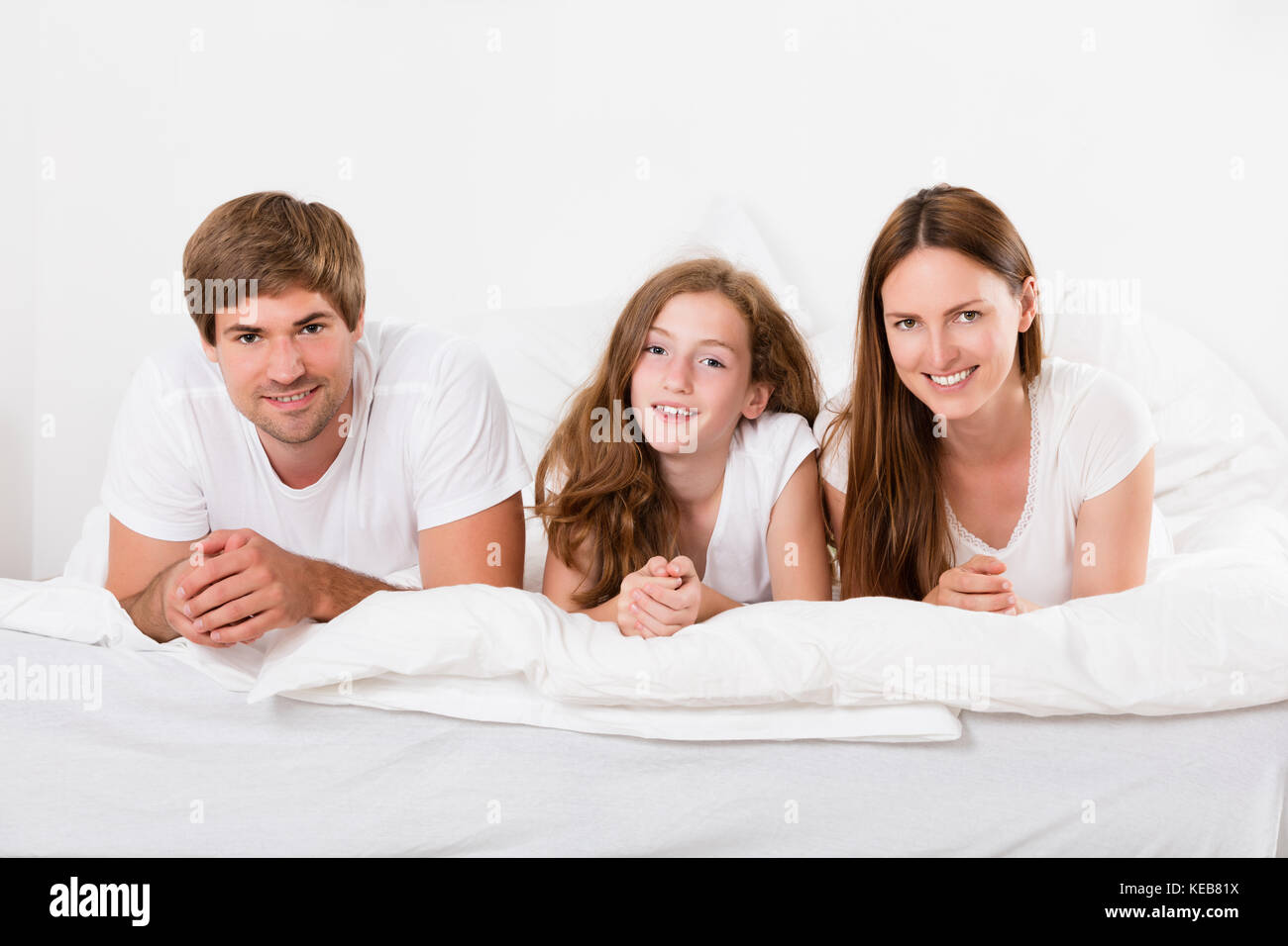 Cheerful girl lying on bed hi-res stock photography and images - Alamy