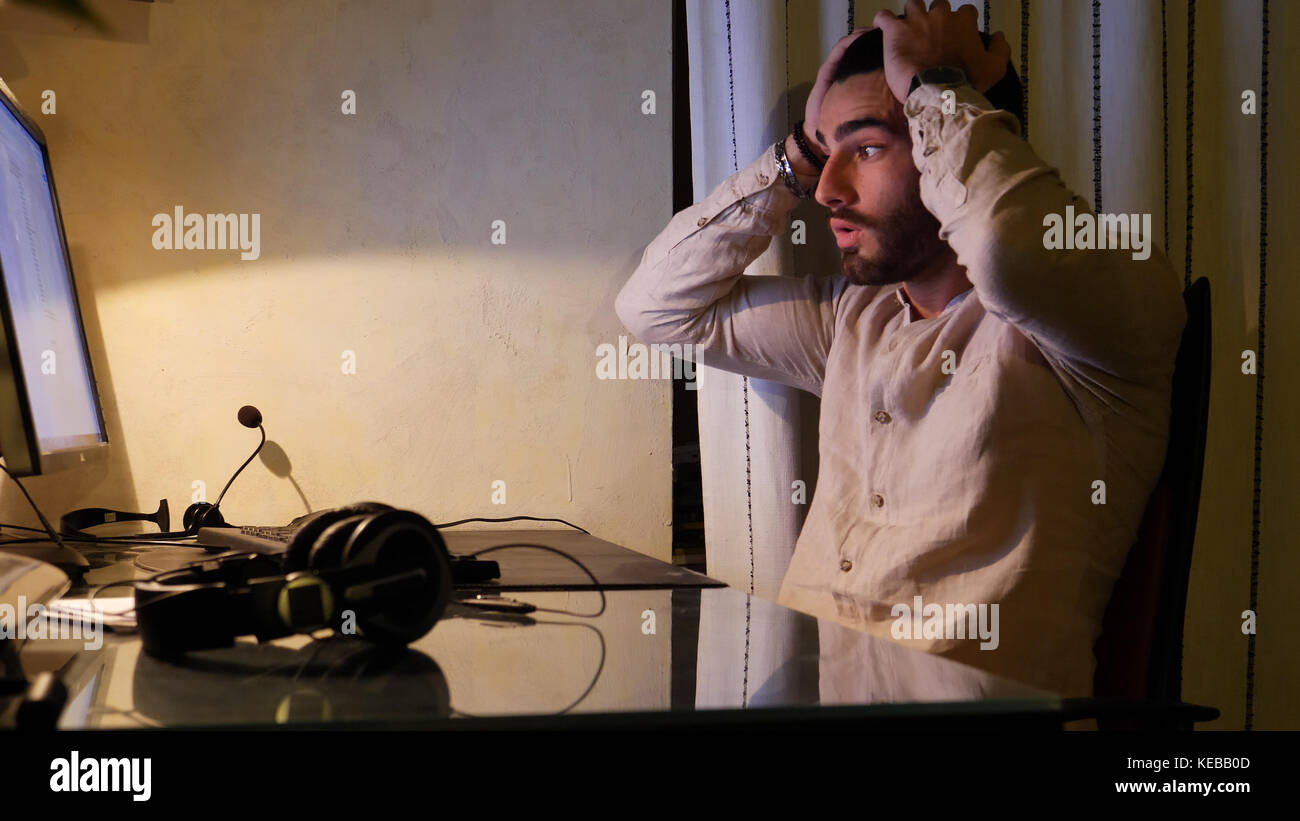 Worried worker sitting at desk at home Stock Photo - Alamy