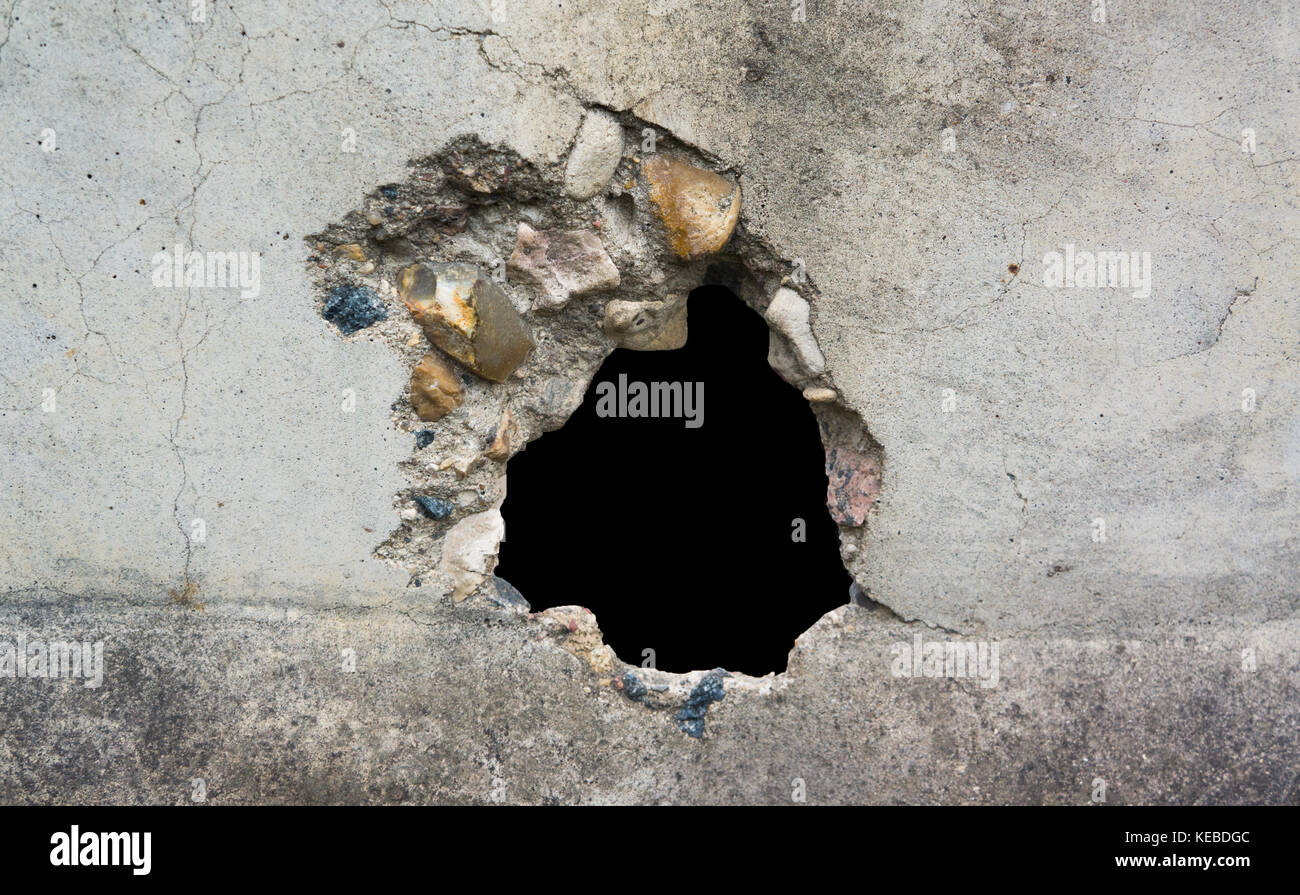 Hole in the destruction concrete wall, bullet hole, abstract background