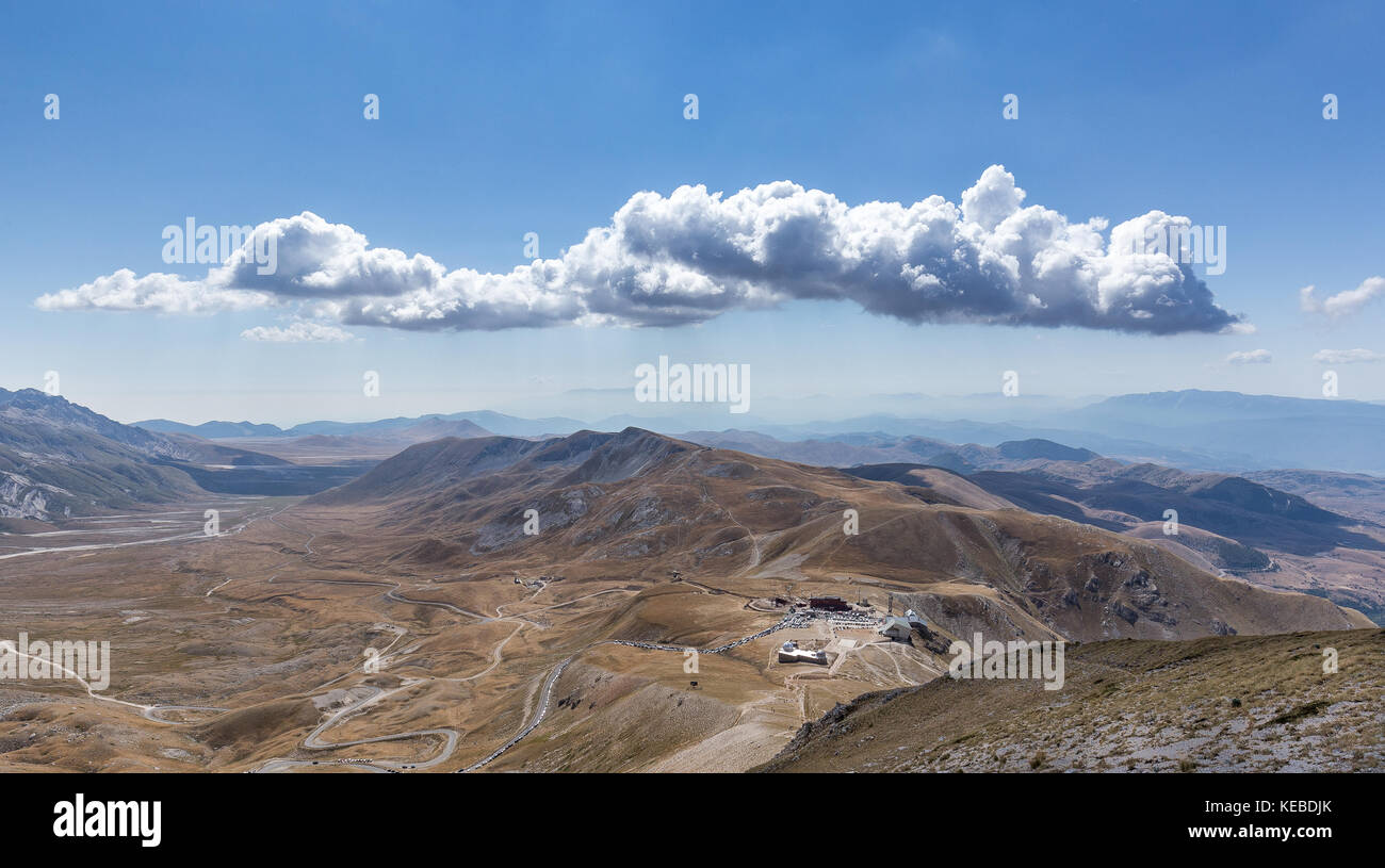 Lonely cloud over mountains range at Campo Imperatore plateau, Abruzzo, Italy Stock Photo