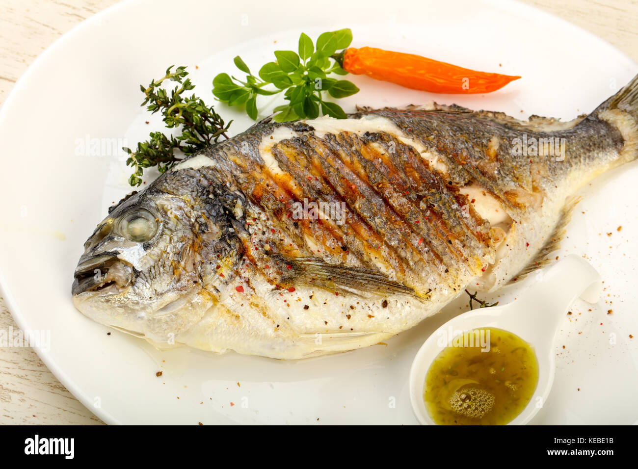 Grilled dorado fish with sauce, thyme and basil Stock Photo - Alamy
