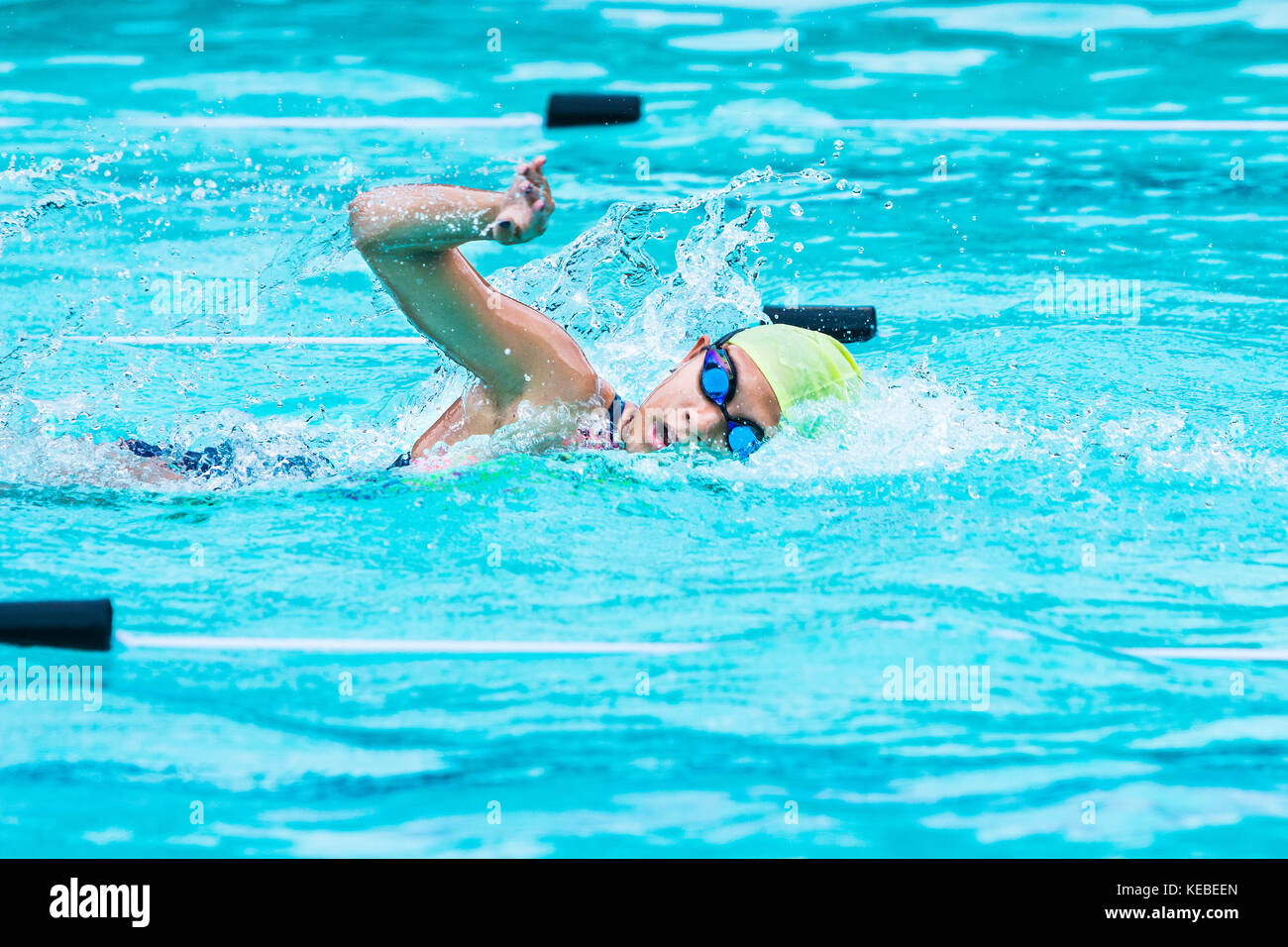 Chiang Mai, Thailand - 11 October 2017 - young female swimmer races in freestyle stroke and turns to catch her breath at a school swimming pool in Chi Stock Photo