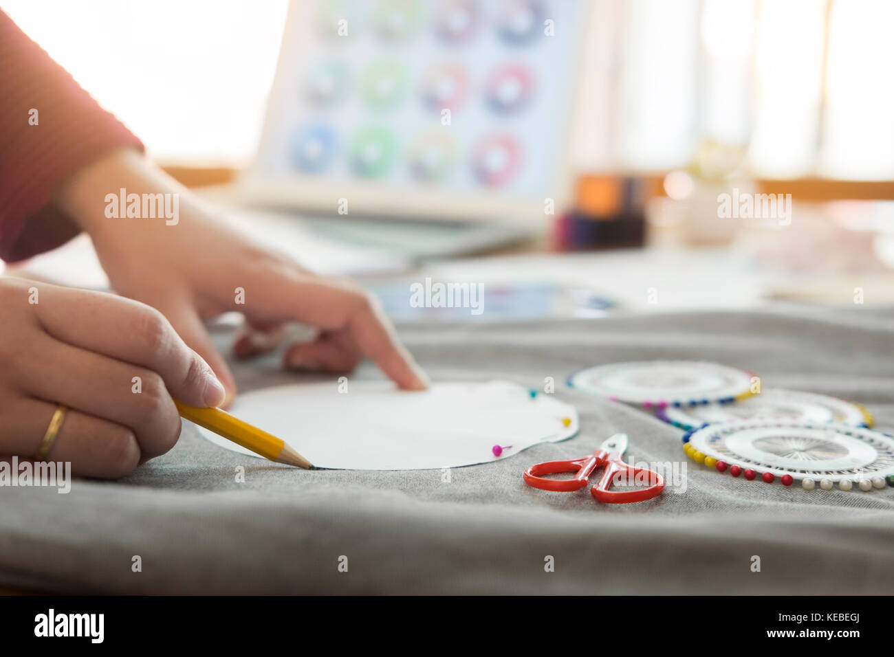 Female fashion designer working with sketches at studio and choosing ...