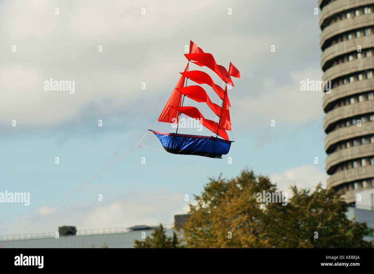 Sailboat sailing across the sky past the building-the personification of dreams Stock Photo