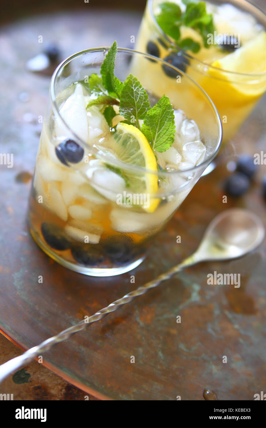 Two glasses of green tea with crushed ice, lemon, fresh blueberries and mint leaves Stock Photo