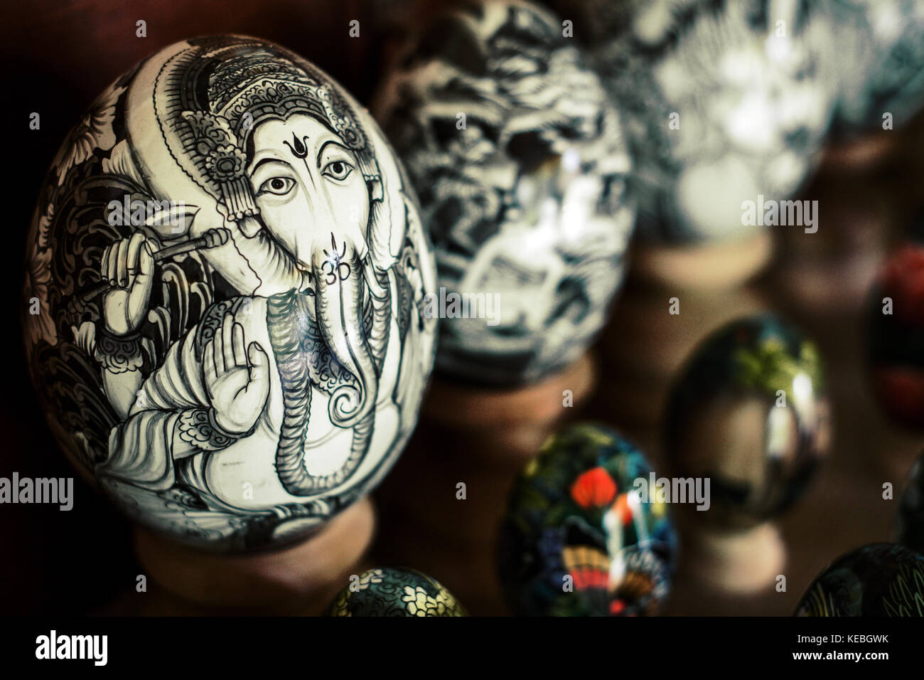 Artistically painted Ostrich eggs overshadow smaller chicken eggs which have all been decorated beautifully with Balinese Hindu Gods and Goddesses Stock Photo