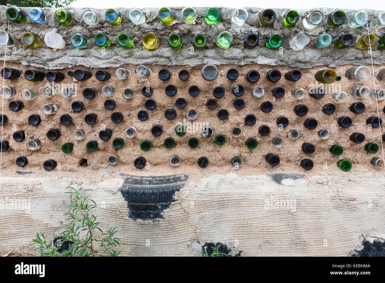 Glass bottles and recycled materials used to construct a wall, Greater World Earthship Community, Near Taos, New Mexico, USA Stock Photo