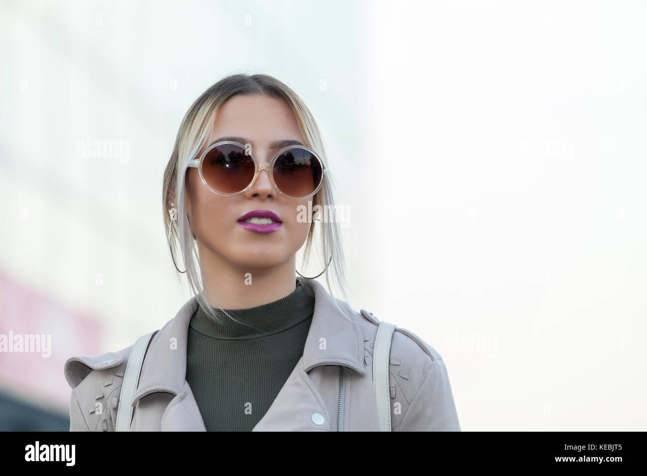 Portrait of a beautiful young modern and urban woman outside with ...