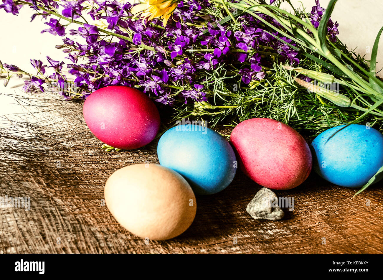 A bouquet of blooming purple wild flowers and painted Easter eggs on a ...