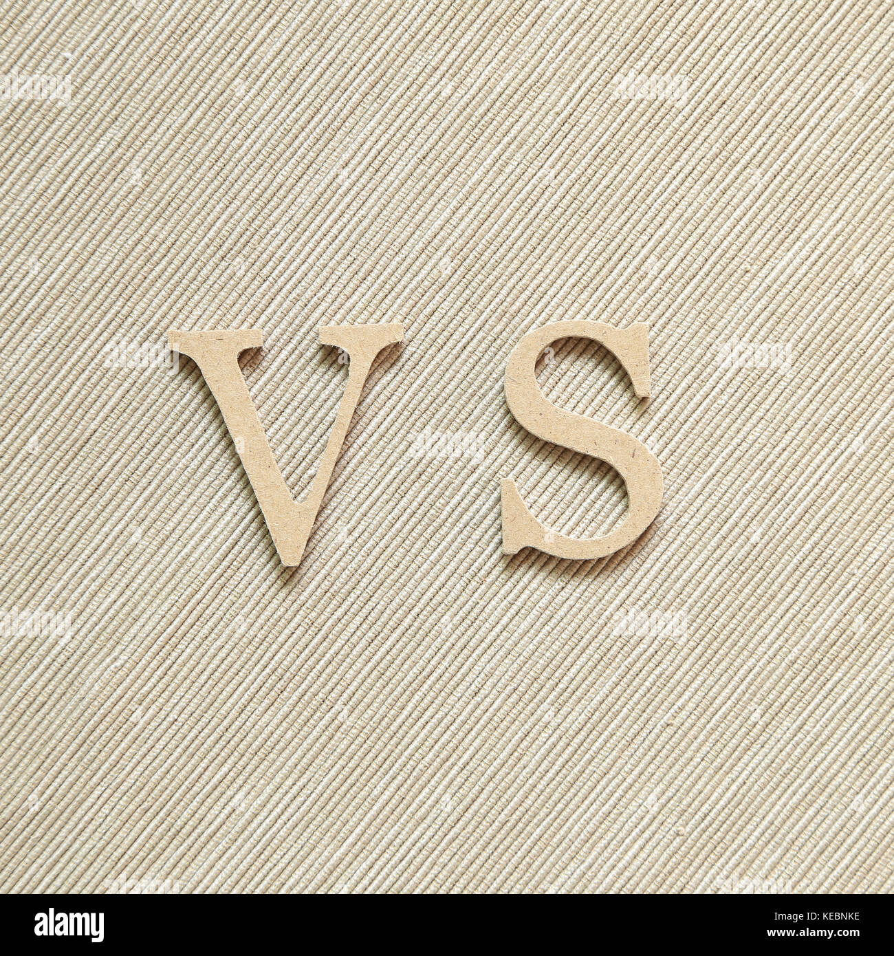 Alphabet VS, versus on brown fabric background Stock Photo