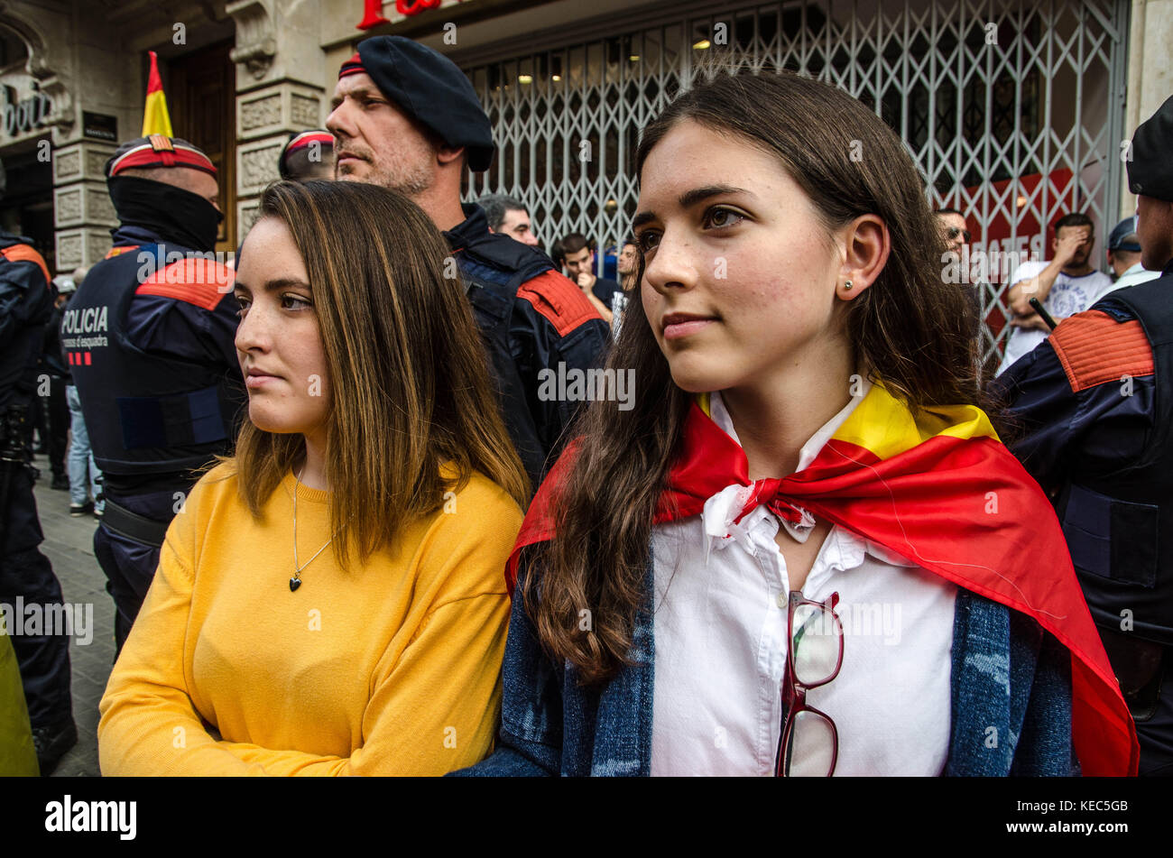 Barcelona, Catalonia, Spain. 12th Oct, 2017. Two young girls are interposed between the Catalan local police and the crowd that is shouting them.Hispanic Heritage Day is being celebrated across Spain. Loyalist organizations urged thousands of citizens have taken to the streets of Barcelona to reaffirm their Spanish national identity and to reject the Catalan sovereignty process. At the end of the rally some protesters have insulted the local police who were making checks to troublemakers. Credit: Copyright Paco Freire/SOPA/ZUMA Wire/Alamy Live News Stock Photo
