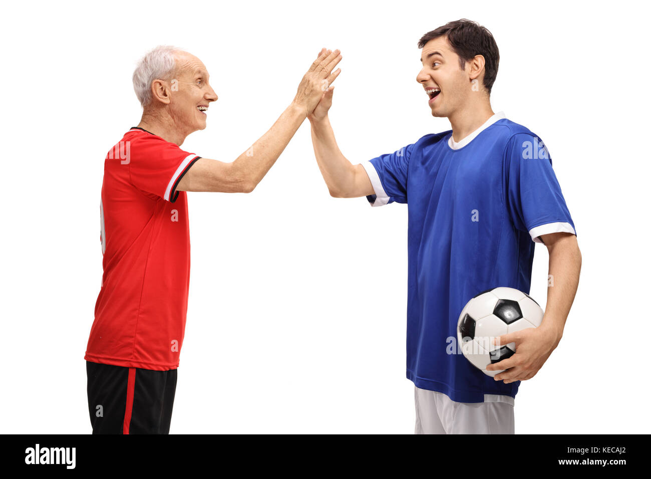 Old footballer and a young footballer high fiving each other isolated on white background Stock Photo