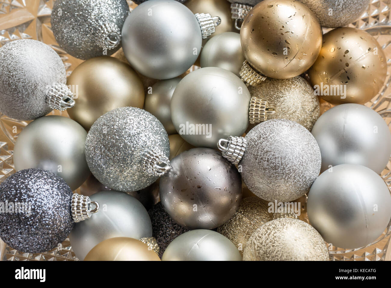 Close up of gold, silver and blue sparkling Christmas  baubles in a crystal bowl Stock Photo
