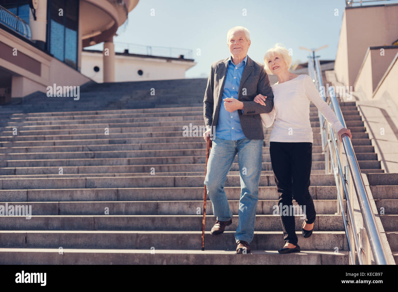 Happy elderly couple going down the stairs Stock Photo - Alamy