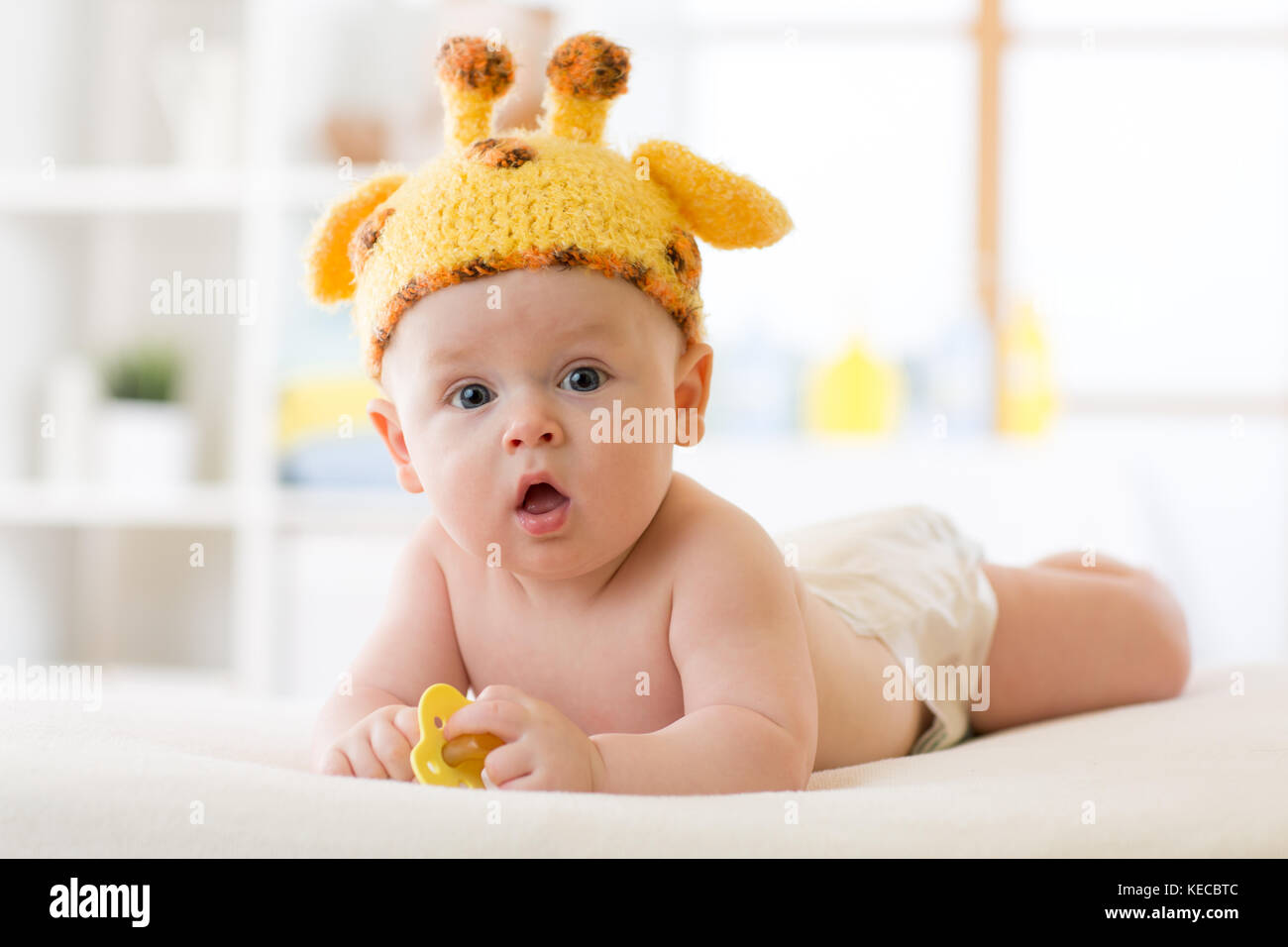 Adorable baby boy lying on tummy and weared funny hat Stock Photo
