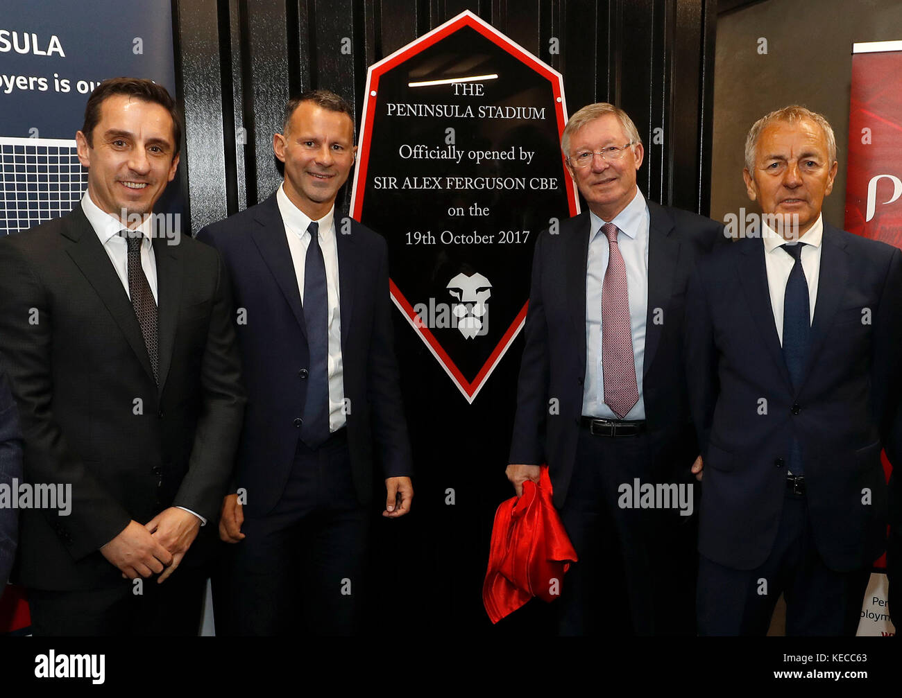 Sir Alex Ferguson unveils a plaque to commemorate the announcement that Salford City's new stadium is named The Peninsula Stadium with Gary Neville (left) Ryan Giggs (2nd left) and managing director of Peninsula Business Services Peter Done (right). Stock Photo