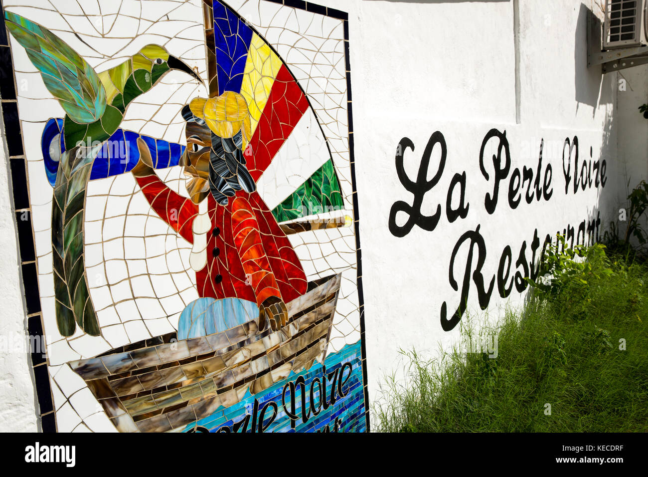 The Seychelles, Mahe, Beau Vallon, creole fisherman’s life and bird tile mosaic sign on wall of La Perle Noire restaurant, Stock Photo