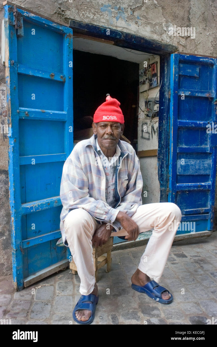 Man in blue sandals & red hat, Rue Oudja, Essaouira, Morocco Stock Photo