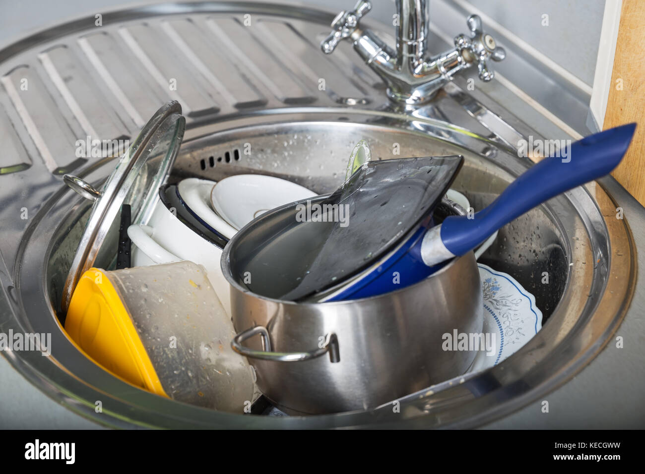 Pile of dirty dishes in kitchen sink Stock Photo