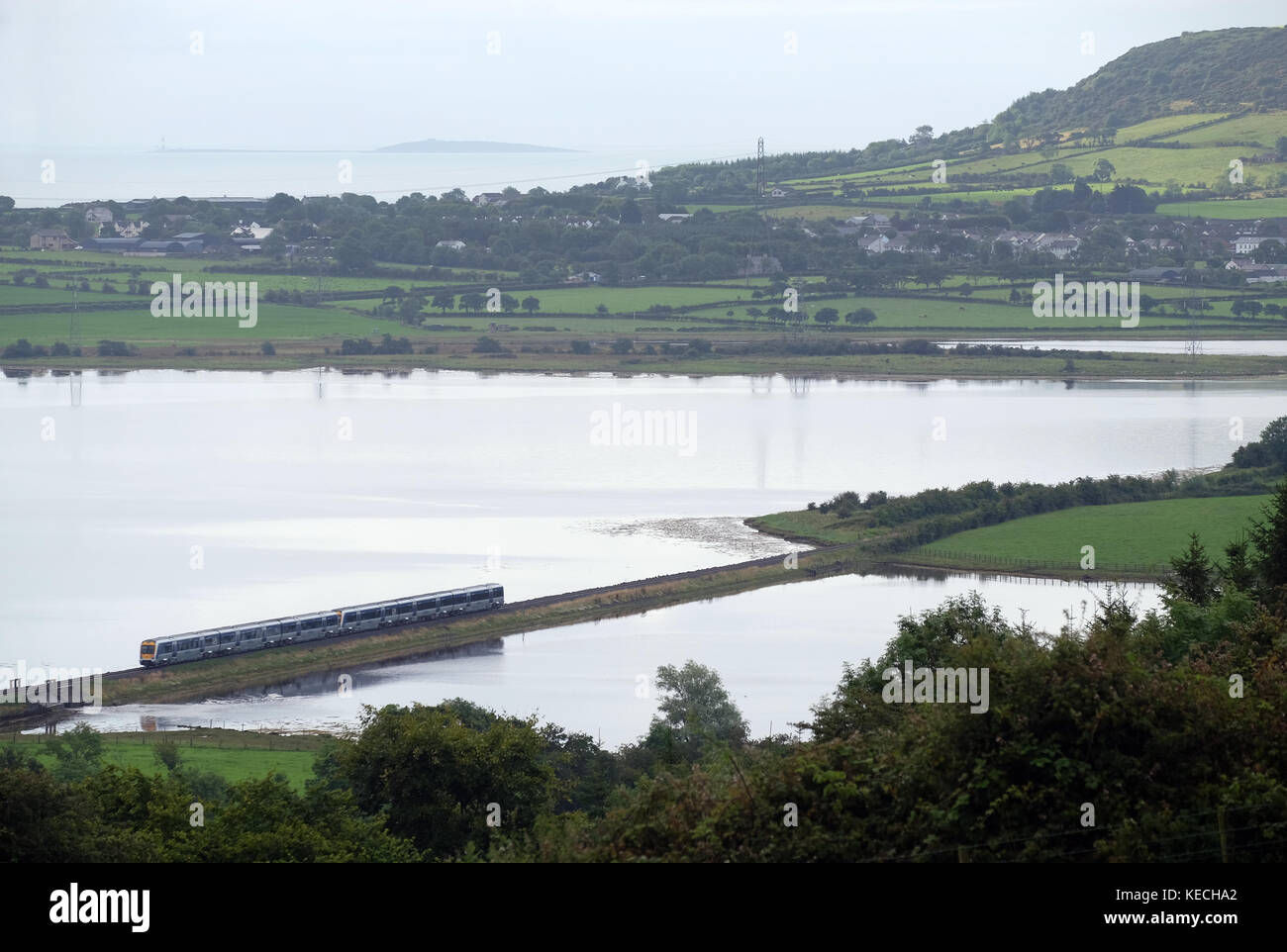 Morning train to Belfast crossing causeway on Larne Lough. Stock Photo