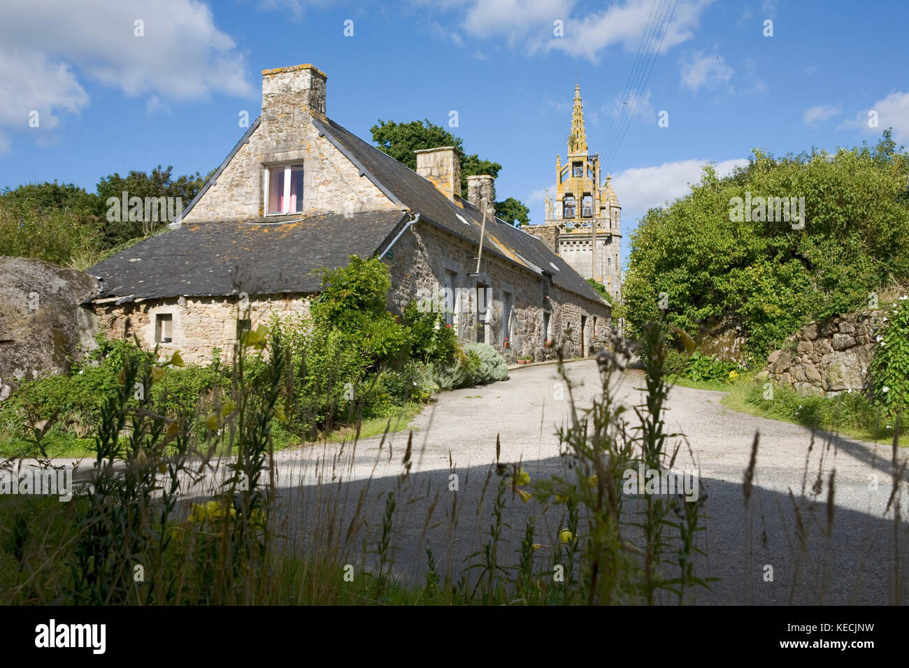 An unusual church tower and a sleepy rural lane with stone cottages, St-Connan, Côtes-d'Armor, Brittany, France Stock Photo