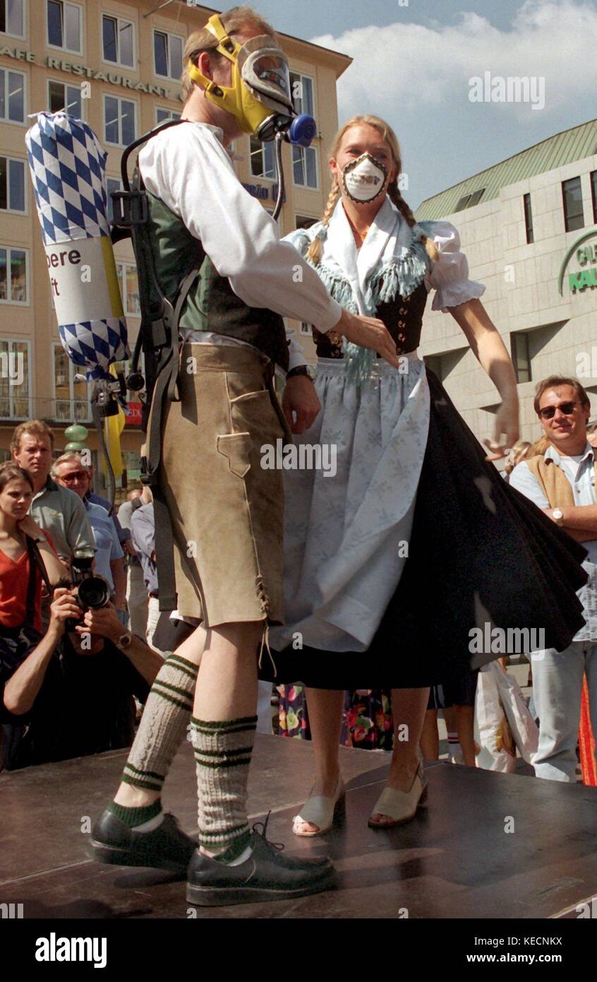 A pair wears traditional German clothes with gas masks on a sunny day, on  30 July 1997, in Munich (Bavaria, Germany). Greenpeace has created these  gas masks as a satirical protest against