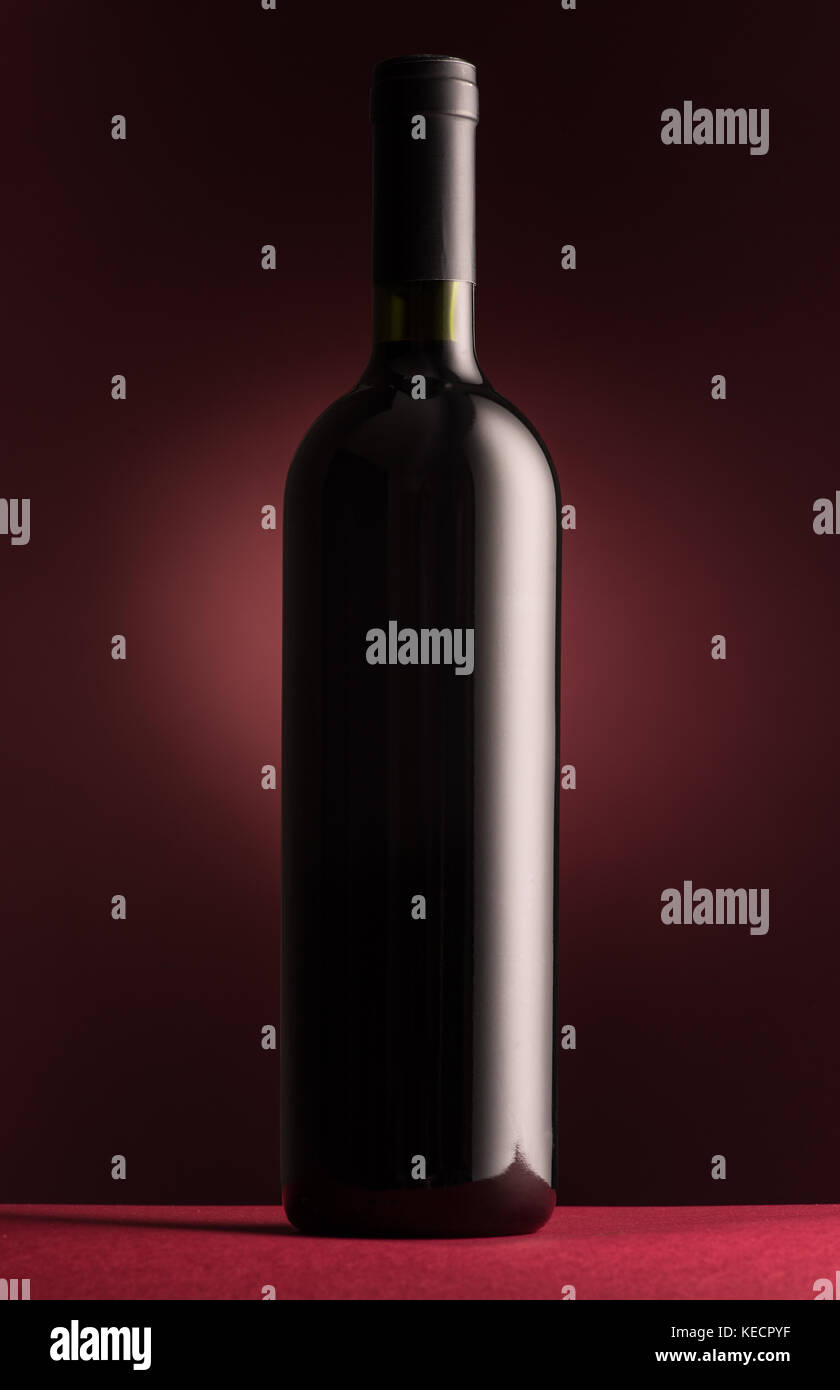 Excellent unlabeled red wine bottle on red background Stock Photo Alamy