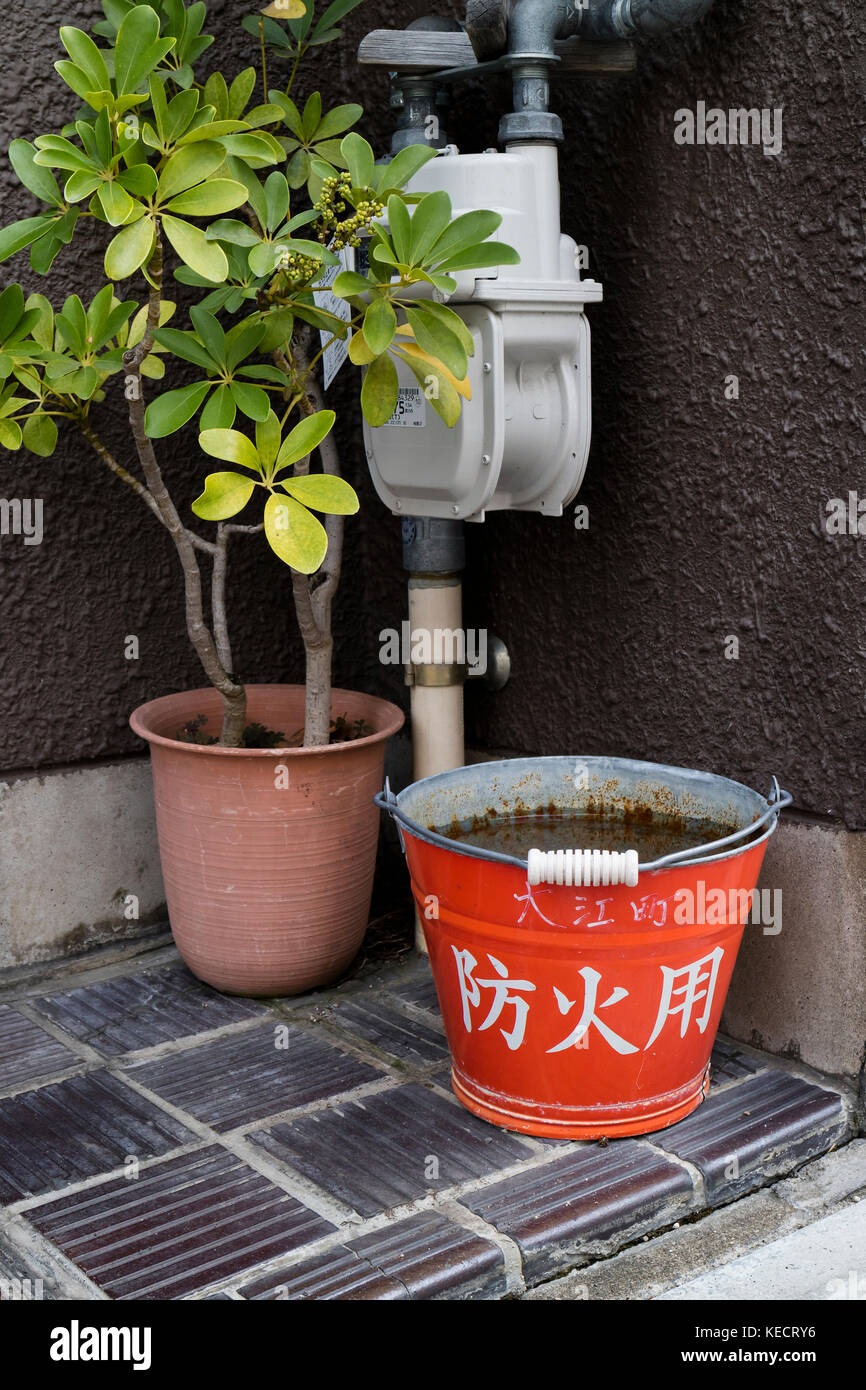 Kyoto, Japan -  May 23, 2017: Traditional red fire bucket with water in front of the house as fire prevention in Kyoto Stock Photo