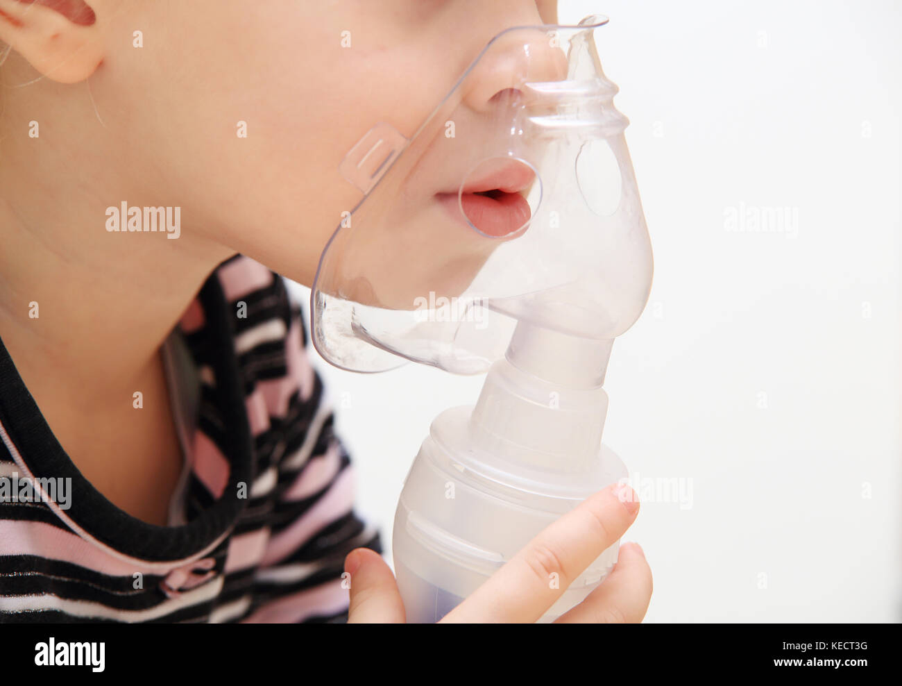 Kid with inhaler isolated on white background. Child holds inhaler mask close-up. Concept of treatment of children's respiratory diseases Stock Photo