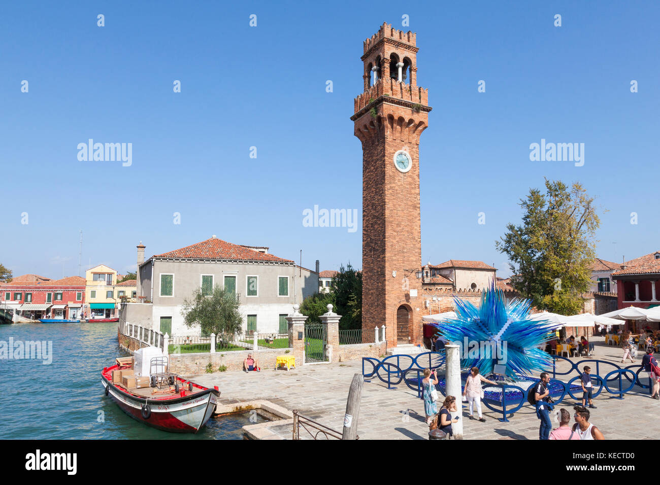 Elevated view of Campo Santo  Stefano and the Comet Glass Star, Murano, Venice, Italy with tourists and a colorful red boat in the canal Stock Photo