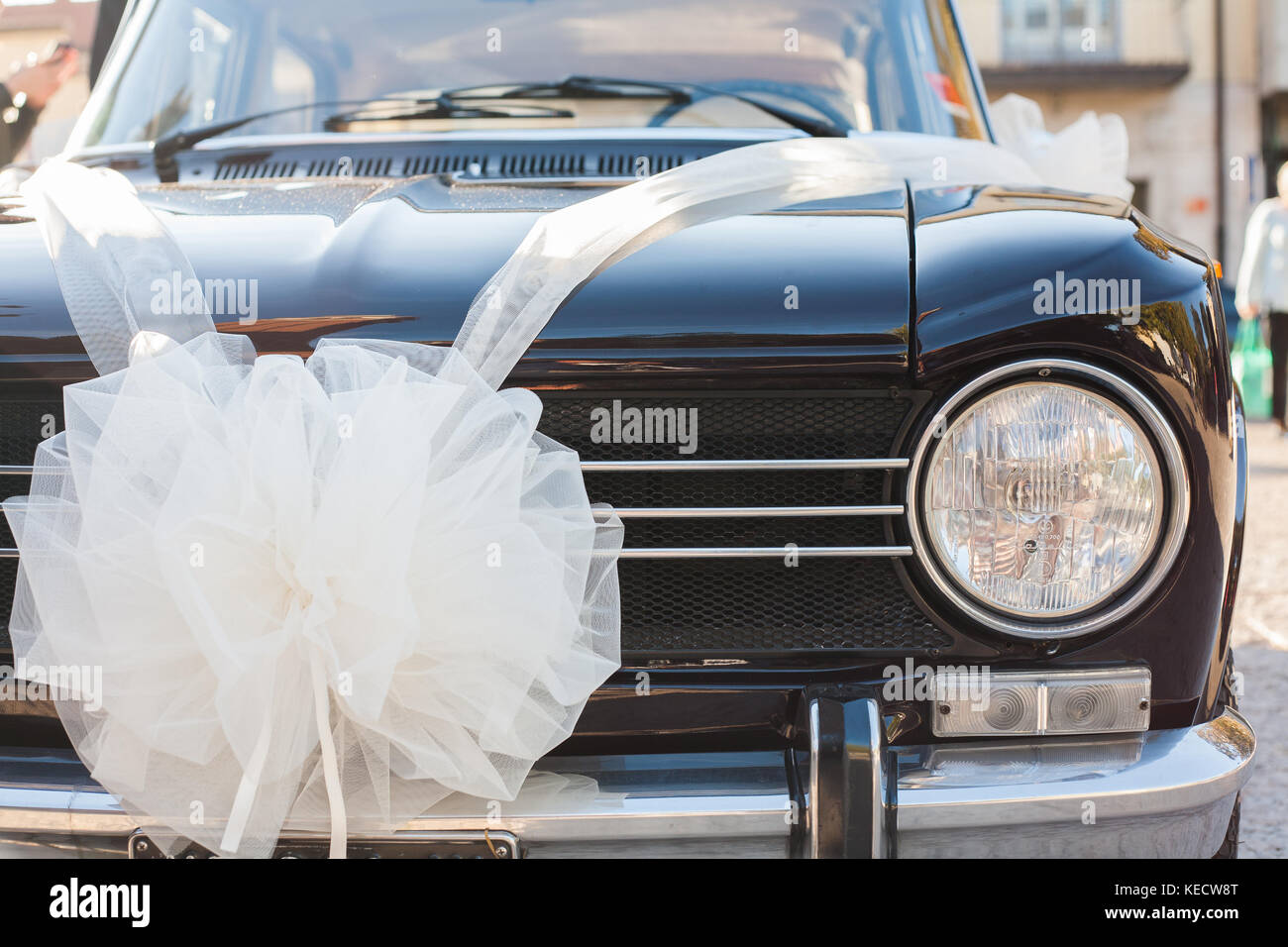 Vintage luxury car ready for wedding day, with clean body and a white ribbon representing the bride's car. Stock Photo